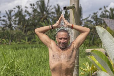 Tropikal su akışı altında pozisyonda meditasyon ve Yoga yapıyor adam Bali, Endonezya ada. Yakın çekim