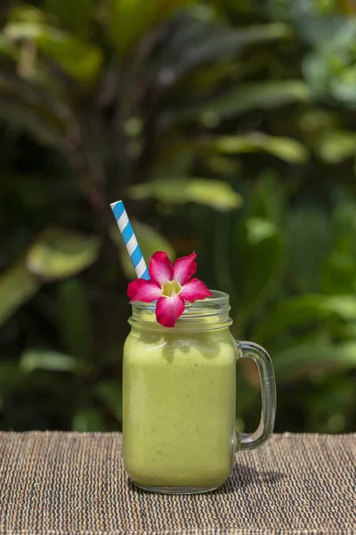 Avocado green shake or smoothie on the table, close up. Breakfast in island Bali, Indonesia — Stock Photo, Image