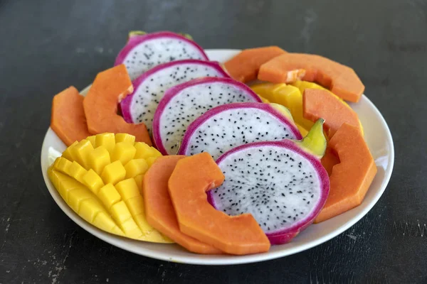 Surtido de frutas tropicales en un plato, primer plano — Foto de Stock