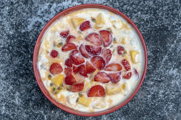 Manga, maracujá, morango e iogurte brulee. Sobremesa de fruto em café da manhã com cunhas de mangas de estação perfeitamente maduras e morango, polpa de maracujá fresca coberta — Fotografia de Stock