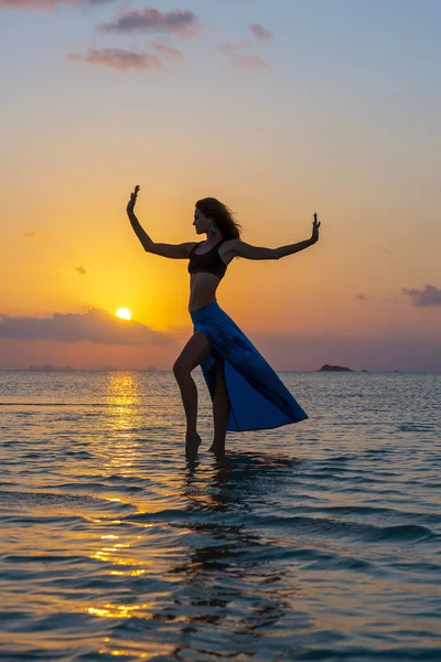 Ung skönhet flicka dansar på tropiska stranden på havsvatten på Paradise Island vid solnedgången. Sommar koncept. Semester resor. — Stockfoto