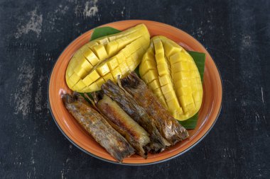 Tay tarzı tatlı, palmiye yaprakları muz yapışkan pirinç sarı Mango. Sarı mango ve yapışkan pirinç Tayland popüler geleneksel gıda. Closeup