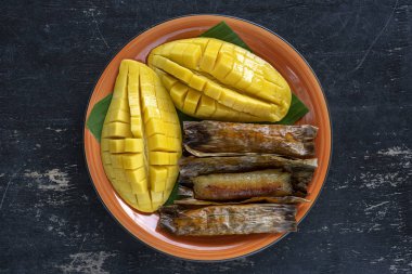 Tay tarzı tatlı, palmiye yaprakları muz yapışkan pirinç sarı Mango. Sarı mango ve yapışkan pirinç Tayland popüler geleneksel gıda. Closeup