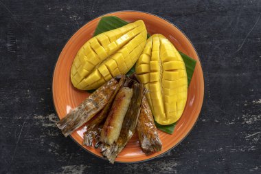 Tay tarzı tatlı, palmiye yaprakları muz yapışkan pirinç sarı Mango. Sarı mango ve yapışkan pirinç Tayland popüler geleneksel gıda. Closeup