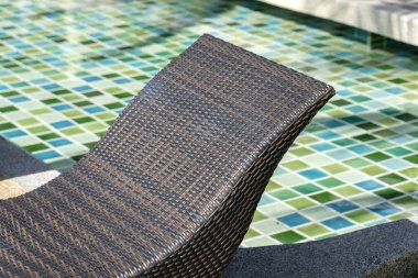 Tropik otelde yüzme havuzu yakınında Rattan şezlong, closeup