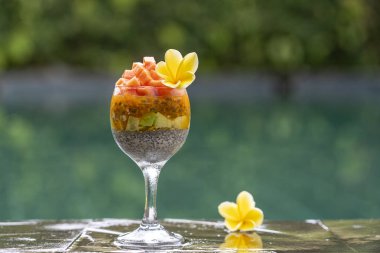 Papaya ile Chia tohumları puding , tutku meyve, mango ve avokado yüzme havuzu su arka planda kahvaltı için bir bardak, closeup. Sağlıklı beslenme kavramı, superfood