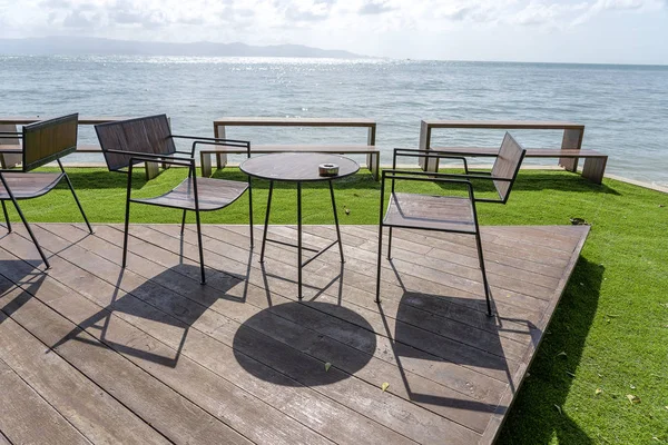 Houten tafel en stoelen in een leeg strandcafé naast zeewater. Eiland Koh Phangan, Thailand — Stockfoto