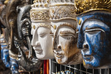 Ubud, Bali, Endonezya sokak pazarında satışa sergilenen Buda görüntü ile ahşap maske. El sanatları ve hediyelik eşya dükkanı ekran