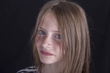 Siyah bir arka plan üzerinde çiller ile güzel sarışın genç kız, closeup portre