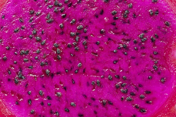 Exotiska rosa dragonfruit klippa makro foto på bakgrunden. Dragon frukt närbild. Pitahaya textur foto. Söt tropisk frukt, saftig pitaya cut — Stockfoto