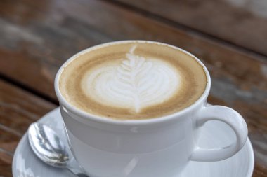 Ahşap masada bir fincan latte kahve, closeup