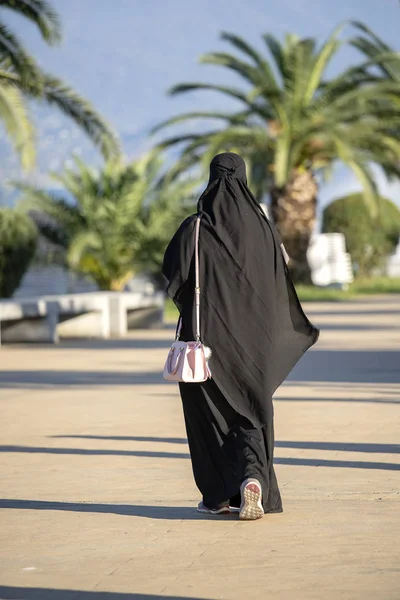 阿拉伯穆斯林女孩穿着黑色长袍在街上 — 图库照片