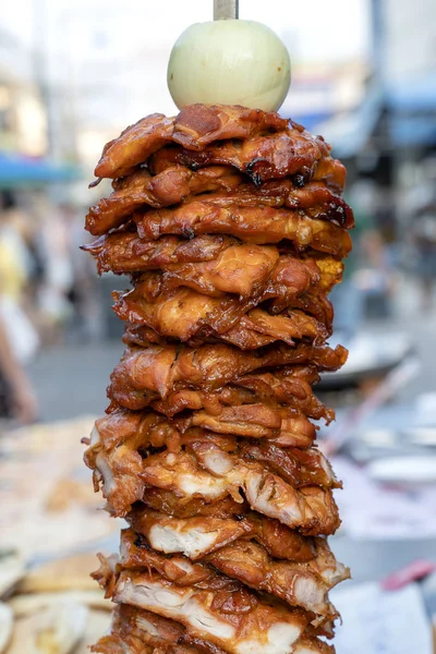 Grandes pedaços de carne em um cuspo no mercado de comida de rua na Tailândia. Carne de chiken espetada no espeto. Fast food . — Fotografia de Stock