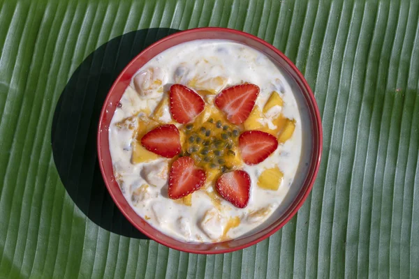 Mango, tutku meyve, çilek ve yoğurt brulee. Mevsimlik mango ve çilek mükemmel olgunlaşmış takozlar ile kahvaltıda meyve tatlı, taze tutku meyve hamuru kaplı — Stok fotoğraf