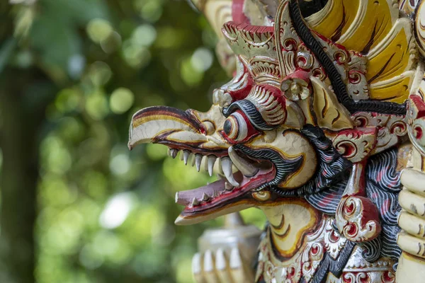 Balinese ancient colorful bird god Garuda with wings, closeup. Religious traditional statue from wood. Wooden old curved figure of Hindu god in Island Bali, Ubud, Indonesia — Stock Photo, Image