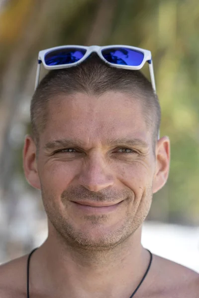 Retrato de un joven con gafas de sol descansando en la playa, de cerca — Foto de Stock