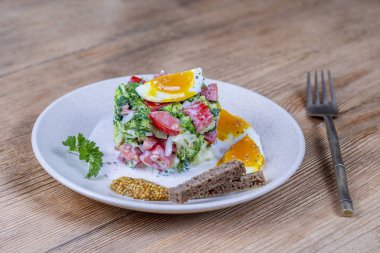 Brokoli, domates, soğan ve ahşap arka plan tabaktabakta krema sos lu haşlanmış yumurta ile lezzetli salata. Sağlıklı gıda