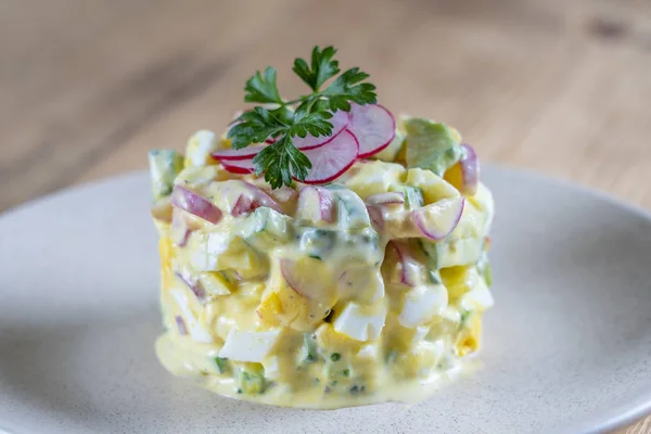 Ahşap arka plan üzerinde bir tabakta salatalık, turp ve krema soslu yumurta ile lezzetli salata. Sağlıklı gıda, yakın — Stok fotoğraf