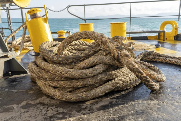 The deck of the ferry boat along with the a thick mooring rope and blue sea water wave, Thailand. Close up — Stock Photo, Image