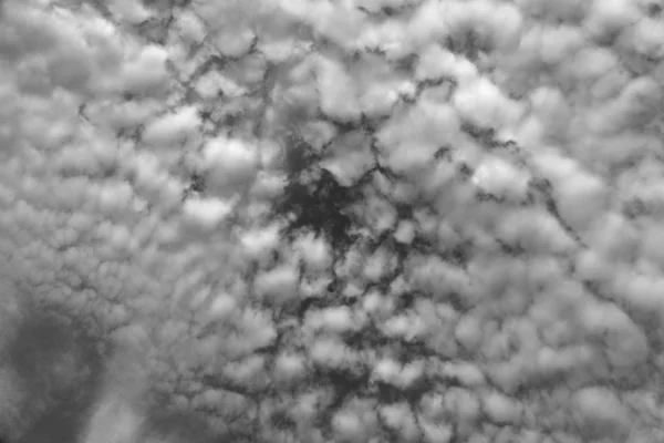 Λευκά σύννεφα πάνω από τον ουρανό. Ουρανός στο παρασκήνιο με σύννεφα. Μαύρο και άσπρο — Φωτογραφία Αρχείου