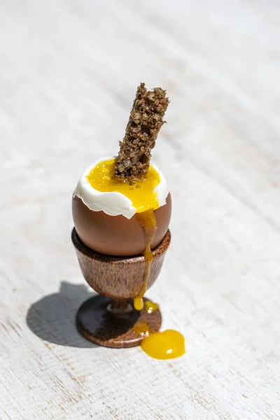 Weich gekochtes Ei in Eierbecher mit Toastbrot auf weißem Holztischhintergrund — Stockfoto