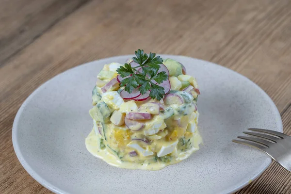 Ahşap arka plan üzerinde bir tabakta salatalık, turp ve krema soslu yumurta ile lezzetli salata. Sağlıklı gıda, yakın — Stok fotoğraf