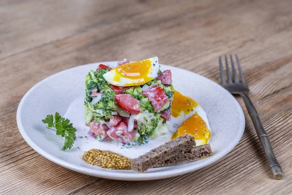 Brokoli, domates, soğan ve ahşap arka plan tabaktabakta krema sos lu haşlanmış yumurta ile lezzetli salata. Sağlıklı gıda — Stok fotoğraf