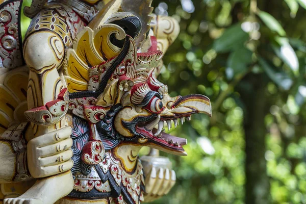 Balinese ancient colorful bird god Garuda with wings, closeup. Religious traditional statue from wood. Wooden old curved figure of Hindu god in Island Bali, Ubud, Indonesia — Stock Photo, Image
