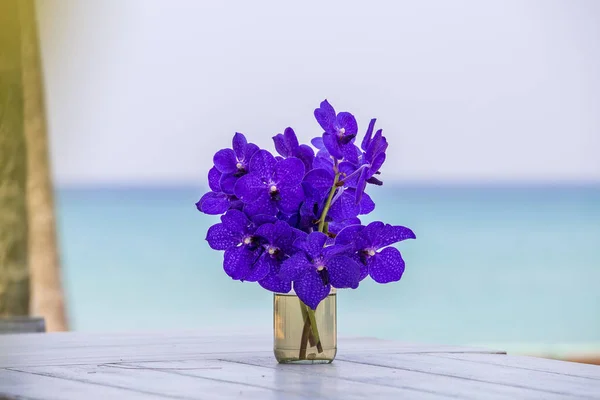 Closeup beautiful bouquet of blue orchids flower on a white wooden table near sea. Thailand — Stock Photo, Image