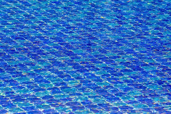 Water ripples on blue tiled swimming pool background. View from above. — Stock Photo, Image