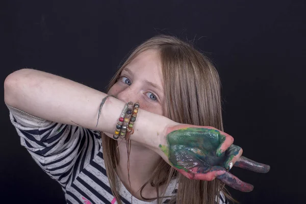 Όμορφη ξανθιά κοπέλα με φακίδες και χέρια βαμμένα σε πολύχρωμα χρώματα στους εσωτερικούς χώρους σε μαύρο φόντο, κοντινό πορτρέτο — Φωτογραφία Αρχείου