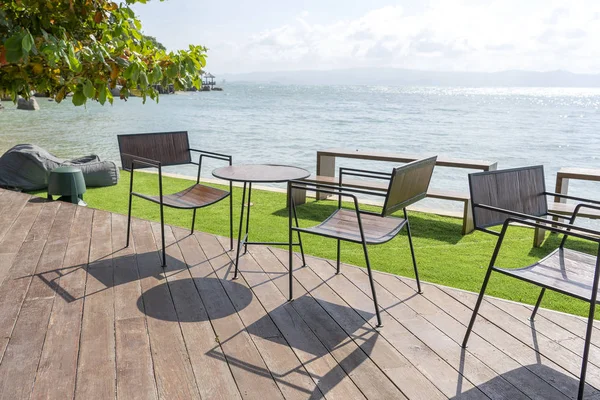 Wooden table and chairs in empty beach cafe next to sea water. Island Koh Phangan, Thailand — Stock Photo, Image