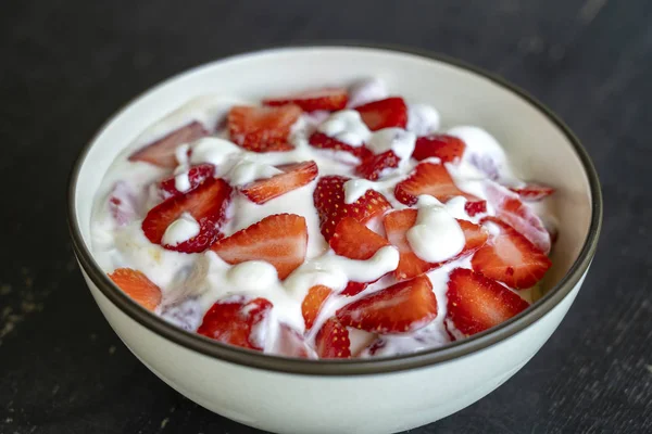 Fresa roja y brulee de yogur blanco. Postre de frutas en el desayuno con cuñas de fresa perfectamente maduras en temporada, primer plano —  Fotos de Stock