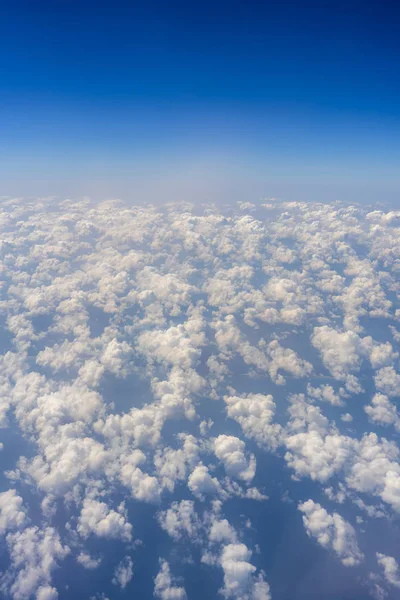 Weiße Wolken und blauer Himmel, ein Blick aus dem Flugzeugfenster — Stockfoto