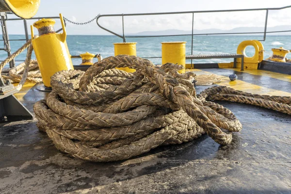厚い係留ロープと青い海の水の波、タイと一緒にフェリーボートのデッキ。クローズアップ — ストック写真