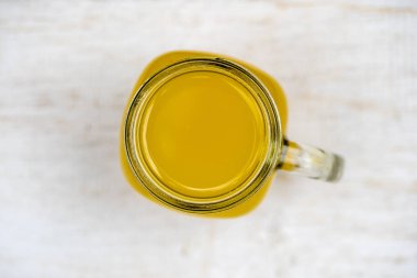 Zerdeçal, zencefil, limon ve balı cam bardakta enerji içeceği, beyaz ahşap arka plan, yakın plan, üst manzara