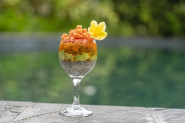 Papaya ile Chia tohumları puding , tutku meyve, mango ve avokado yüzme havuzu su arka planda kahvaltı için bir bardak, closeup. Sağlıklı beslenme kavramı, superfood