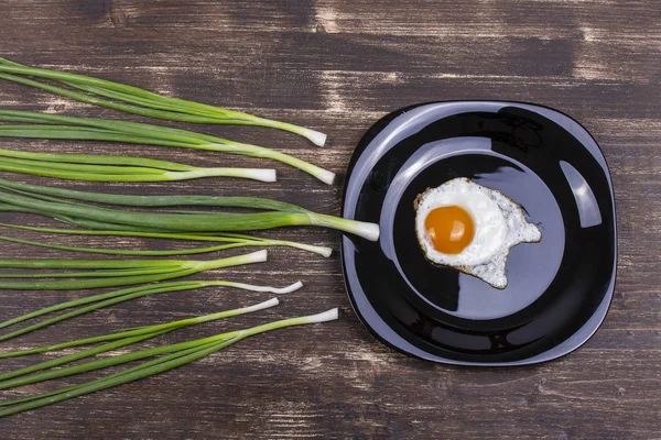 Αυγό, σχοινόπρασο, πράσινο κρεμμύδι και μαύρη πλάκα μοιάζουν με ανταγωνισμό σπέρματος, Spermatozoons που επιπλέει σε ωάριο. Σκούρο ξύλινο φόντο, κορυφή θέα — Φωτογραφία Αρχείου