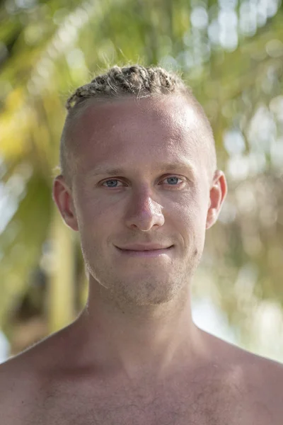 Retrato de un joven con rastas en la cabeza en la naturaleza. De cerca. — Foto de Stock