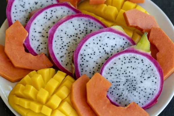 Surtido de frutas tropicales en un plato, primer plano — Foto de Stock