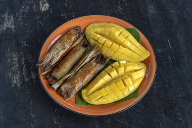 Tay tarzı tatlı, palmiye yaprakları muz yapışkan pirinç sarı Mango. Sarı mango ve yapışkan pirinç Tayland popüler geleneksel gıda. Closeup