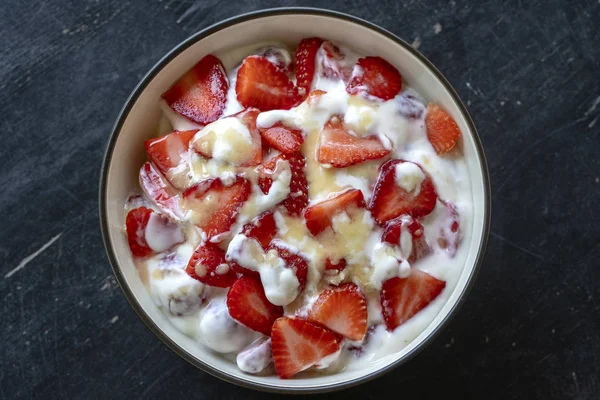 Rote Erdbeere und weißer Joghurt brulee. Fruchtdesserts zum Frühstück mit Keilen perfekt reifer Erdbeeren der Saison, Nahaufnahme — Stockfoto