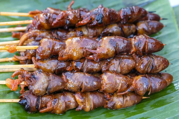 Thai street vendor sells grilled chicken hearts at street food market in island Koh Phangan, Thailand. Closeup — Stock Photo, Image