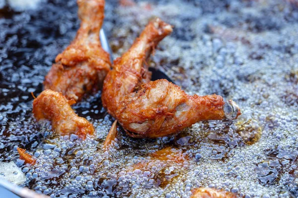 O vendedor de rua tailandês vende carne grelhada de pernas de frango no mercado de comida de rua na Tailândia. Fritar pernas de frango em uma panela de perto — Fotografia de Stock