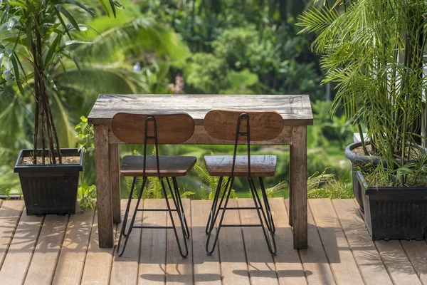 Wooden table and chairs in empty tropical cafe next to rice terraces in island Bali, Indonesia — Stock Photo, Image