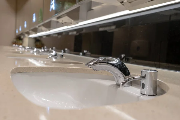 Faucets with washbasin in public restroom, close up — Stock Photo, Image