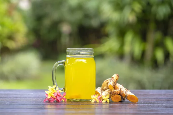 Ενεργειακό τονωτικό ποτό με κουρκούμη, τζίντζερ, λεμόνι και μέλι σε γυάλινη κούπα, φόντο φύσης, κοντινό πλάνο — Φωτογραφία Αρχείου