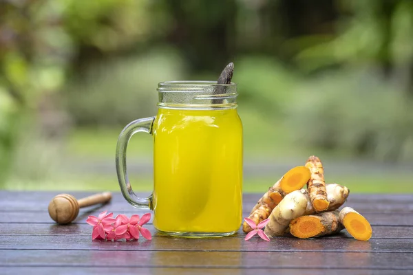 Energia bebida tônica com açafrão, gengibre, limão e mel em caneca de vidro, fundo da natureza, close-up — Fotografia de Stock