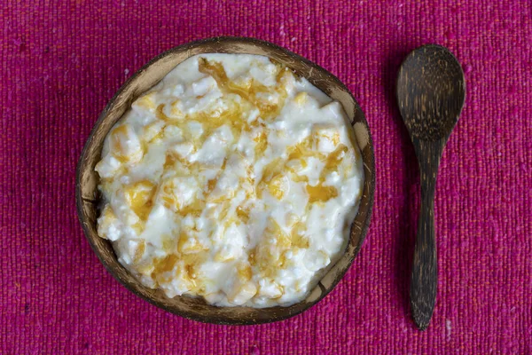 Fatias de manga amarela doce madura com queijo cottage branco, mel e creme de leite em tigela de coco, close-up — Fotografia de Stock