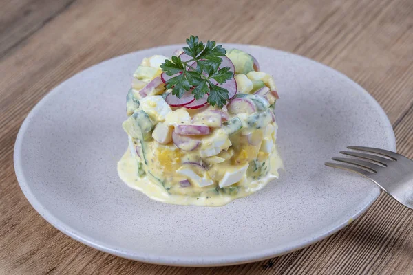 Ensalada deliciosa con pepino, rábano y huevo con salsa de crema en un plato sobre fondo de madera. Comida sana, de cerca — Foto de Stock